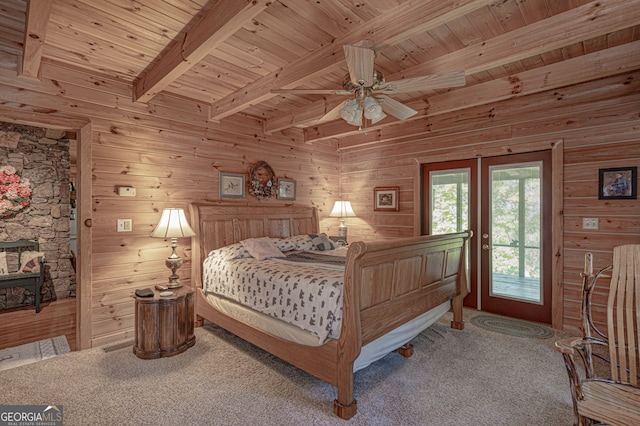 carpeted bedroom featuring wooden ceiling, access to outside, wooden walls, ceiling fan, and beamed ceiling