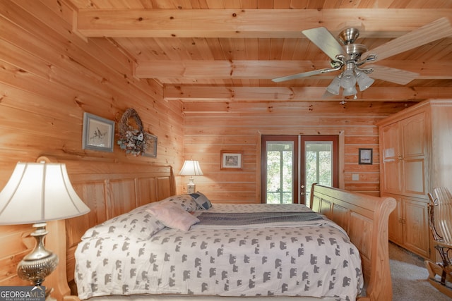 bedroom featuring beamed ceiling, french doors, access to exterior, and wooden walls