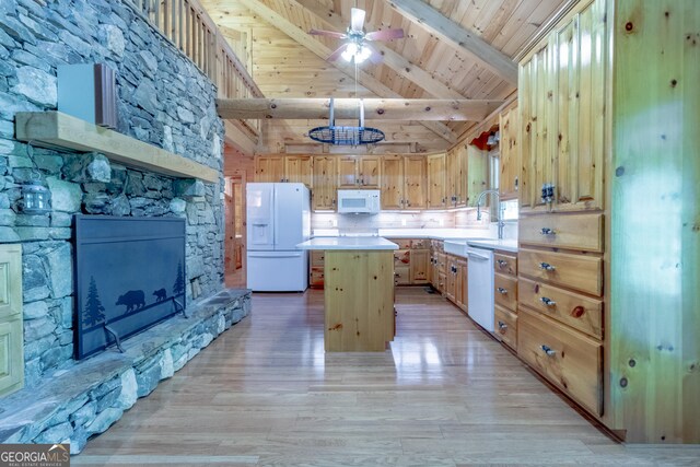 739 Barnes Mill Rd, Hamilton, GA 31811 - kitchen with light wood-style floors, beamed ceiling, white appliances, a center island, and light countertops