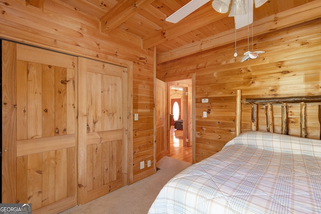 bedroom featuring carpet flooring, wood ceiling, ceiling fan, wooden walls, and beam ceiling