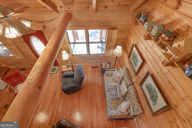 living room featuring hardwood / wood-style flooring, lofted ceiling with beams, wood walls, and wood ceiling