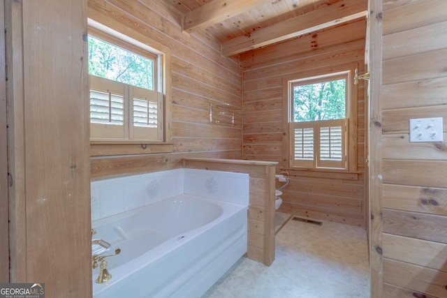 739 Barnes Mill Rd, Hamilton, GA 31811 - bathroom with toilet, a healthy amount of sunlight, wooden walls, and a garden tub