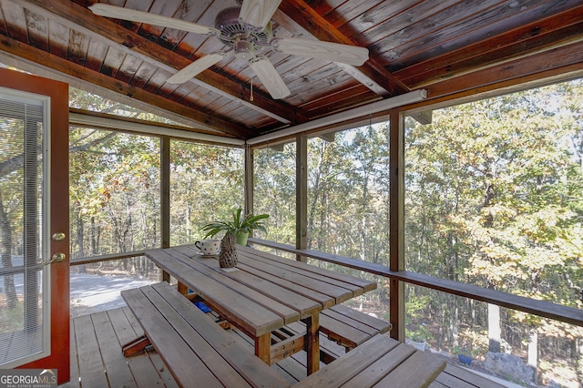 unfurnished sunroom with lofted ceiling with beams, wooden ceiling, and a healthy amount of sunlight