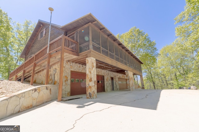 739 Barnes Mill Rd, Hamilton, GA 31811 - view of home's exterior featuring a sunroom, stone siding, a garage, and driveway