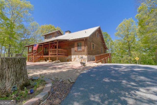 739 Barnes Mill Rd, Hamilton, GA 31811 - view of side of home with covered porch, log exterior, a chimney, and metal roof