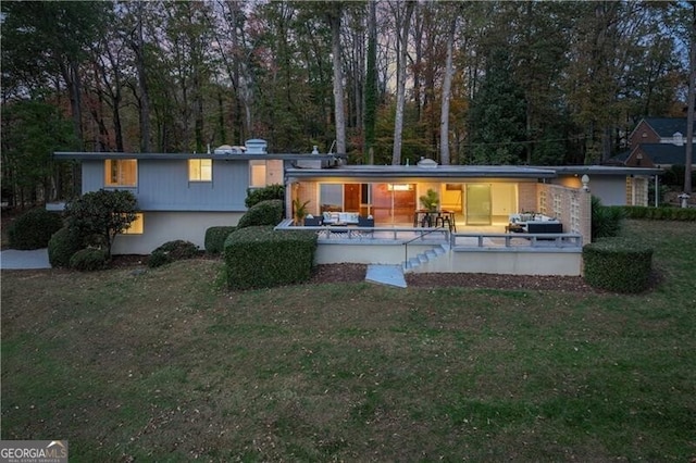 rear view of house featuring a lawn