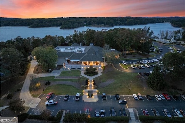 aerial view at dusk featuring a water view