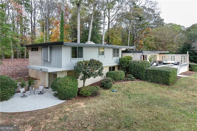 rear view of house with a patio area and a lawn