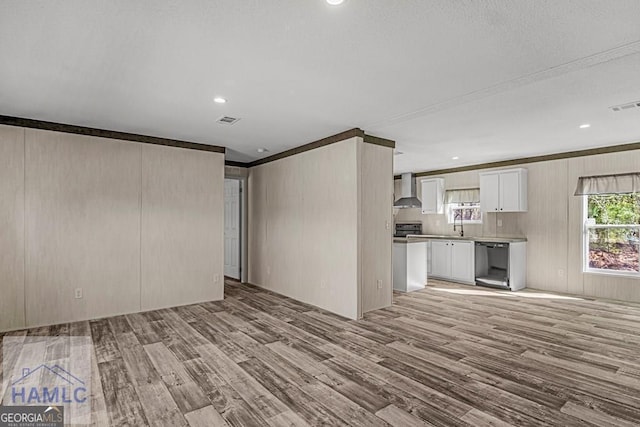 unfurnished living room featuring ornamental molding and light wood-type flooring