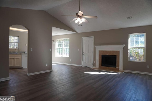 unfurnished living room featuring sink, vaulted ceiling, dark hardwood / wood-style floors, ceiling fan, and a textured ceiling