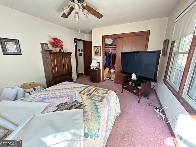 bedroom with ceiling fan, light carpet, and a closet