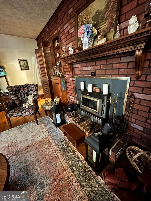 living room with hardwood / wood-style flooring, a textured ceiling, and brick wall