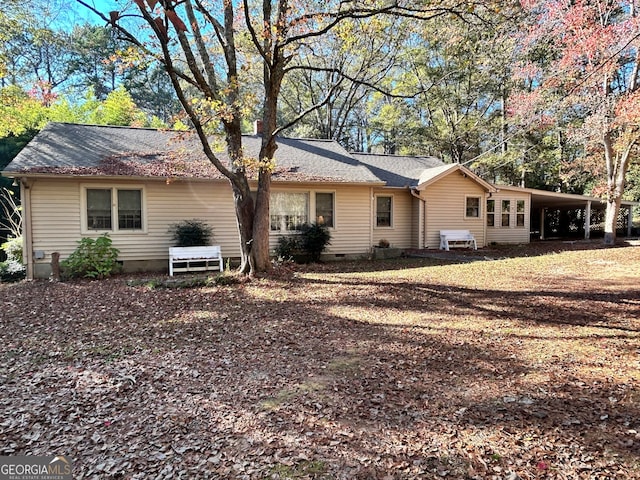 back of house featuring a carport