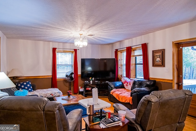 living room with a textured ceiling, hardwood / wood-style flooring, and a notable chandelier