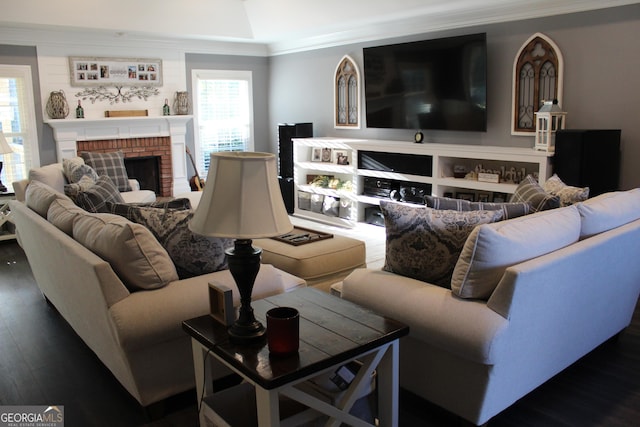 living room with crown molding, dark hardwood / wood-style flooring, and a fireplace