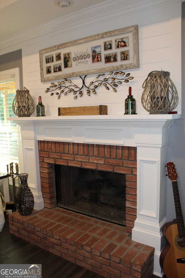 room details featuring hardwood / wood-style floors, a brick fireplace, and ornamental molding