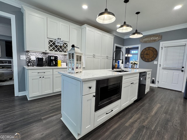 kitchen with black appliances, a center island with sink, sink, hanging light fixtures, and white cabinetry