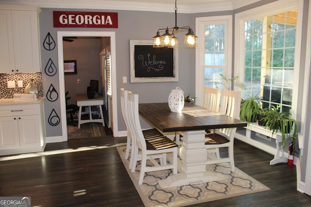 dining room featuring crown molding, dark wood-type flooring, and a chandelier