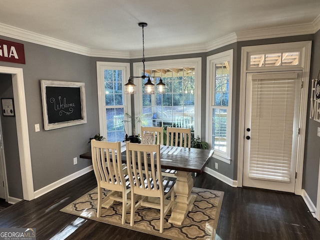 dining space with crown molding, dark hardwood / wood-style flooring, and an inviting chandelier