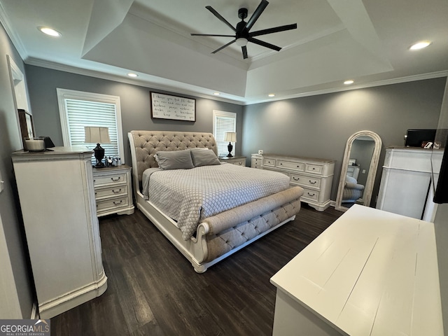 bedroom featuring a tray ceiling, crown molding, ceiling fan, and dark wood-type flooring