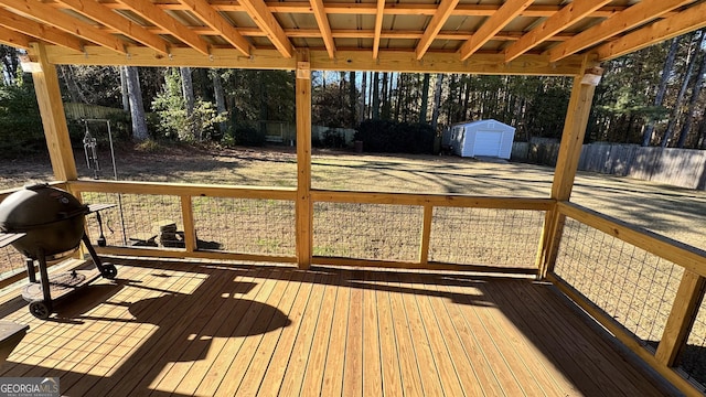 wooden deck featuring grilling area and a storage shed