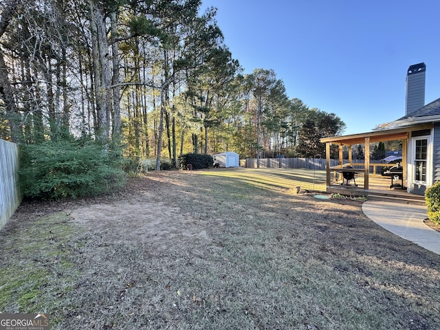 view of yard featuring a storage shed and a wooden deck