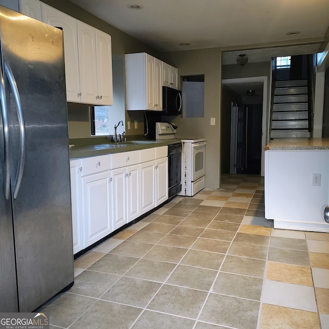 kitchen with black appliances, light tile patterned flooring, white cabinetry, and sink