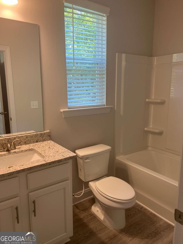 full bathroom with shower / washtub combination, hardwood / wood-style floors, vanity, and toilet