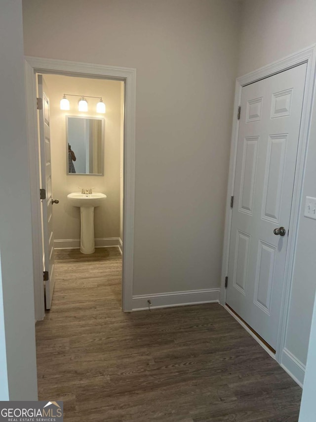 hallway with dark hardwood / wood-style flooring and sink