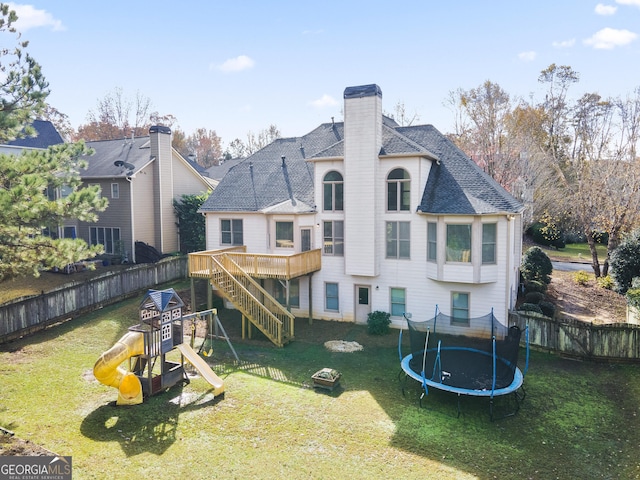 back of property featuring a playground, a trampoline, and a lawn