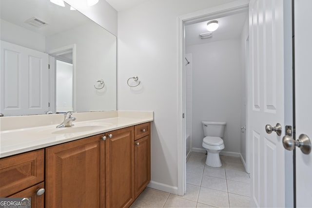 bathroom with toilet, vanity, and tile patterned floors