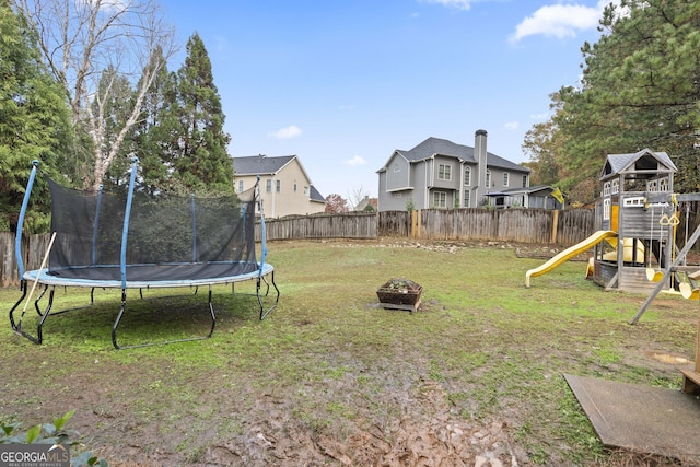 view of yard featuring a playground and a trampoline