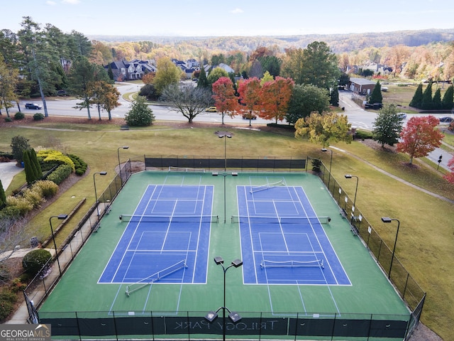 view of tennis court with a yard