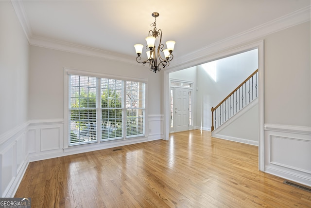 interior space with ornamental molding, light hardwood / wood-style floors, and a notable chandelier