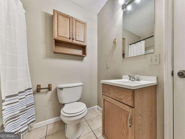 bathroom featuring vanity, a textured ceiling, tile patterned floors, and toilet