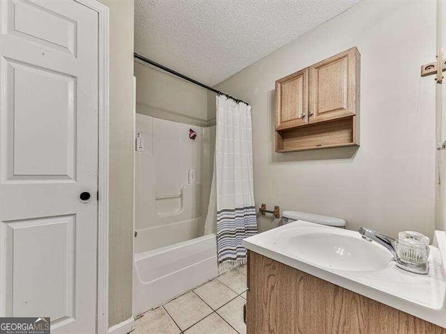 bathroom with tile patterned flooring, vanity, a textured ceiling, and shower / tub combo