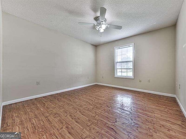 spare room featuring hardwood / wood-style floors, ceiling fan, and a textured ceiling