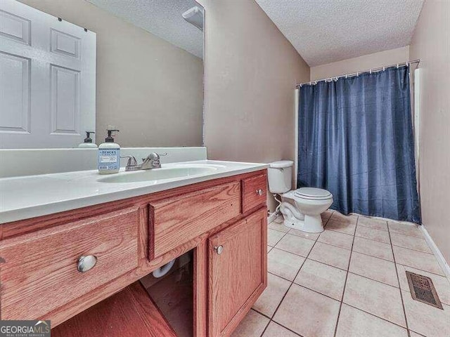 bathroom with tile patterned flooring, vanity, toilet, and a textured ceiling