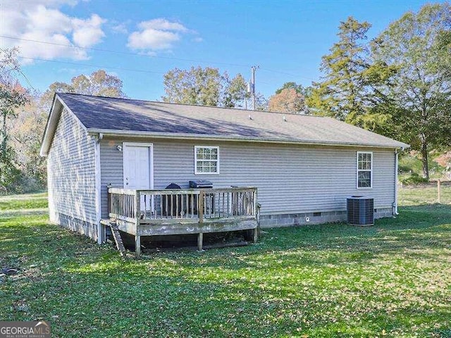 rear view of house featuring central AC unit, a lawn, and a wooden deck