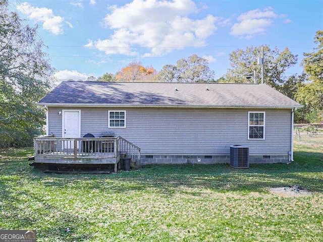 rear view of property featuring a yard, cooling unit, and a wooden deck