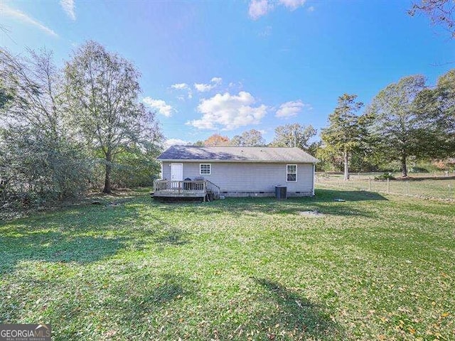 back of house featuring a deck, a yard, and central AC