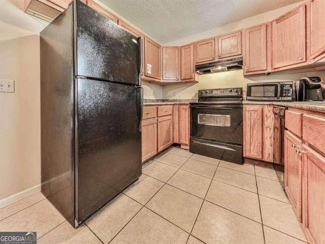 kitchen with light tile patterned flooring, black appliances, and a textured ceiling