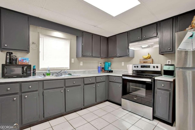 kitchen featuring gray cabinetry, light tile patterned floors, sink, and appliances with stainless steel finishes