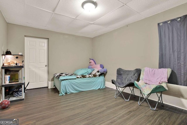 bedroom with dark hardwood / wood-style floors and a drop ceiling