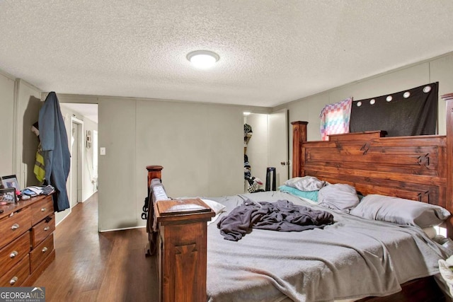 bedroom with dark hardwood / wood-style flooring and a textured ceiling