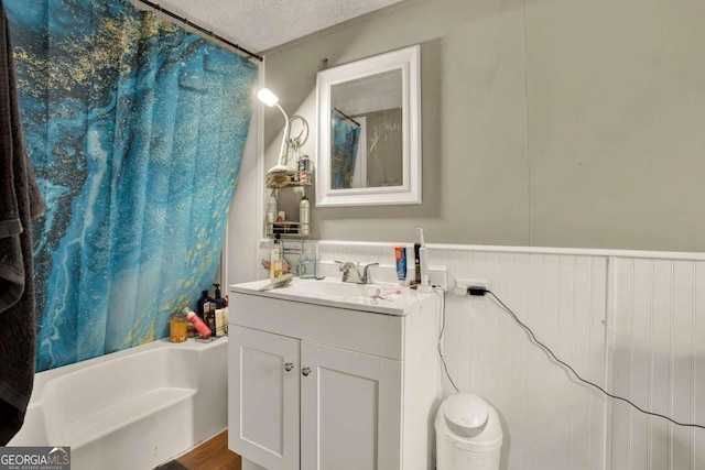 bathroom with shower / bathing tub combination, vanity, wood-type flooring, and a textured ceiling