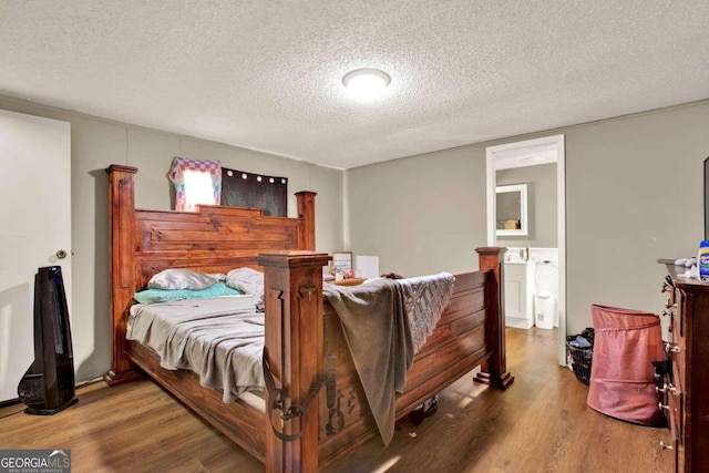 bedroom with a textured ceiling and hardwood / wood-style flooring