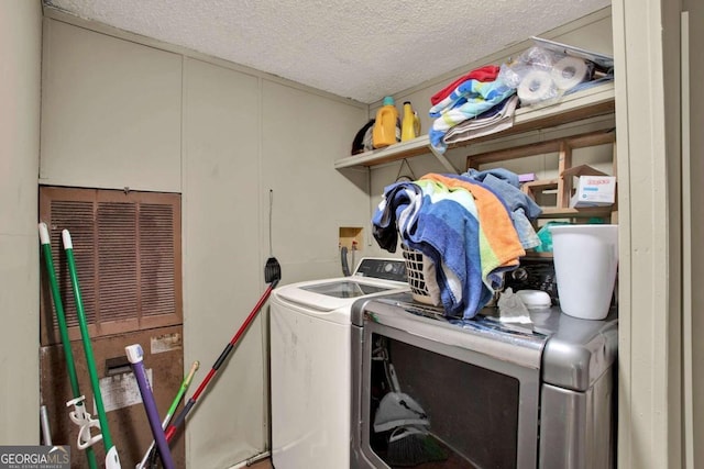 clothes washing area with a textured ceiling and washing machine and dryer