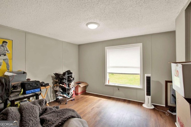 misc room featuring hardwood / wood-style flooring, a fireplace, and a textured ceiling