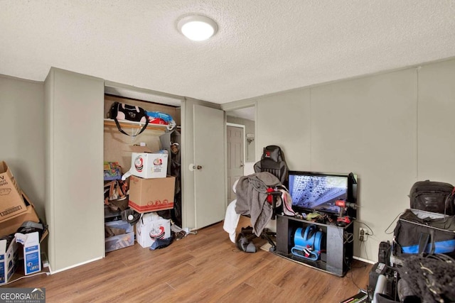 interior space featuring wood-type flooring and a textured ceiling